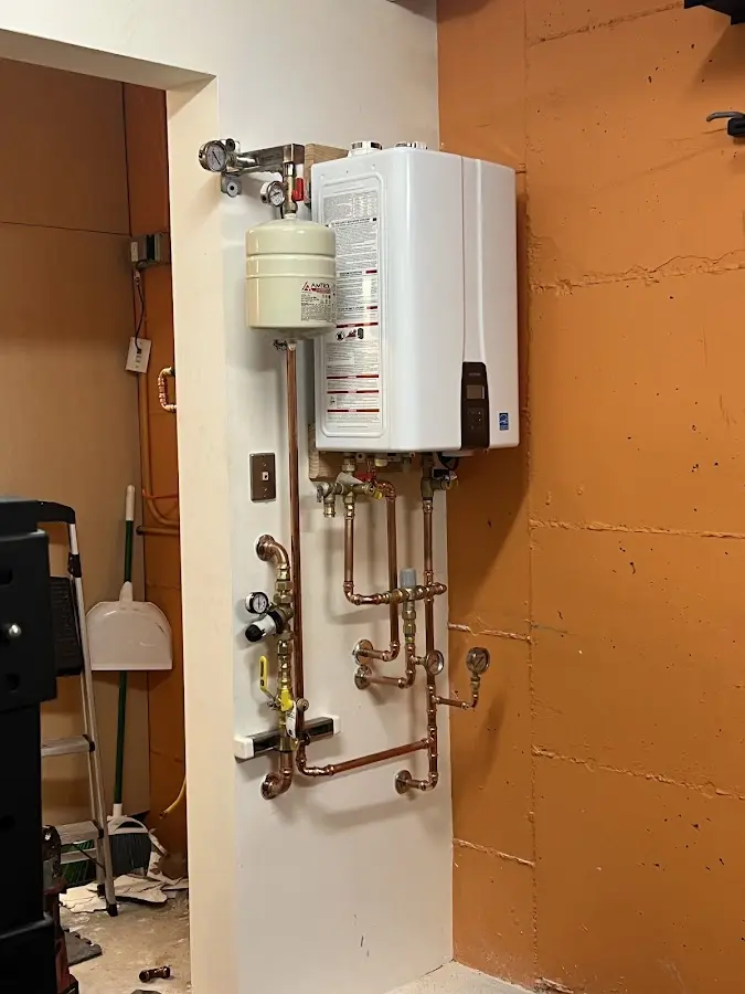 Plumbing technician inspecting water heater connections in Carmel
